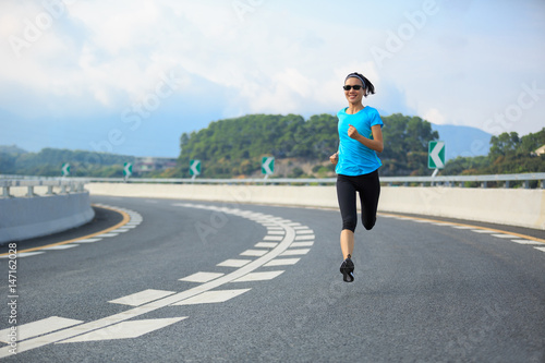 Healthy lifestyle young fitness woman running at city road © lzf