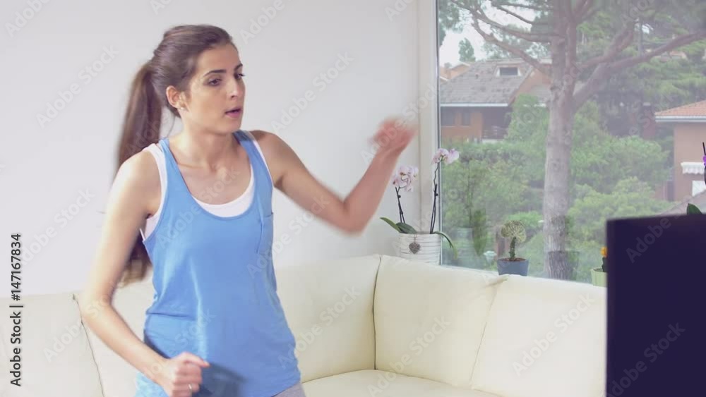 Woman at home making funny exercise gym in front of tv Woman at home making funny exercise gym in front of tv