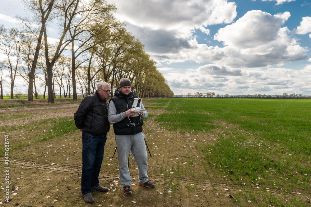 father and son operating of flying drone quadrocopter at the green field father and son operating of flying drone quadrocopter at the green field