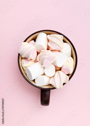 Sweet marshmallow in cup, candy on pink background, top view flat lay. Isolated minimal concept above decoration, view white marshmallow, food background