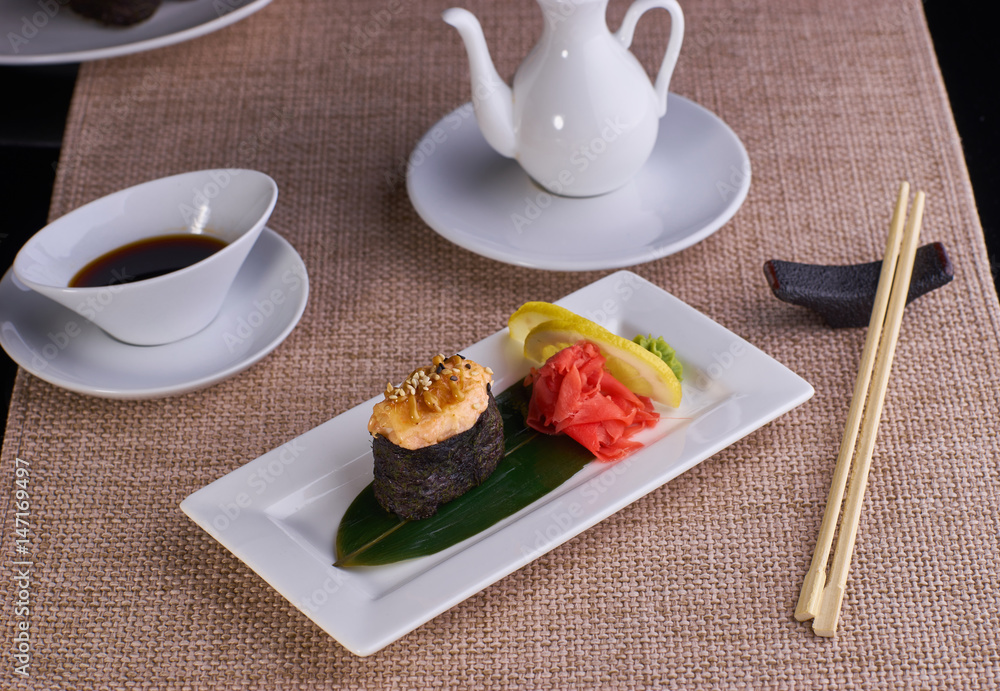 baked sushi with salmon served with chopsticks and soy sauce on table baked sushi with salmon served with chopsticks and soy sauce on table