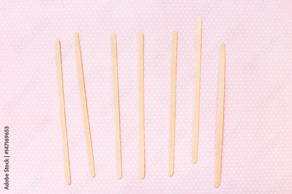 Mixers, wooden sticks for coffee and tea, pink background Mixers, wooden sticks for coffee and tea, pink background