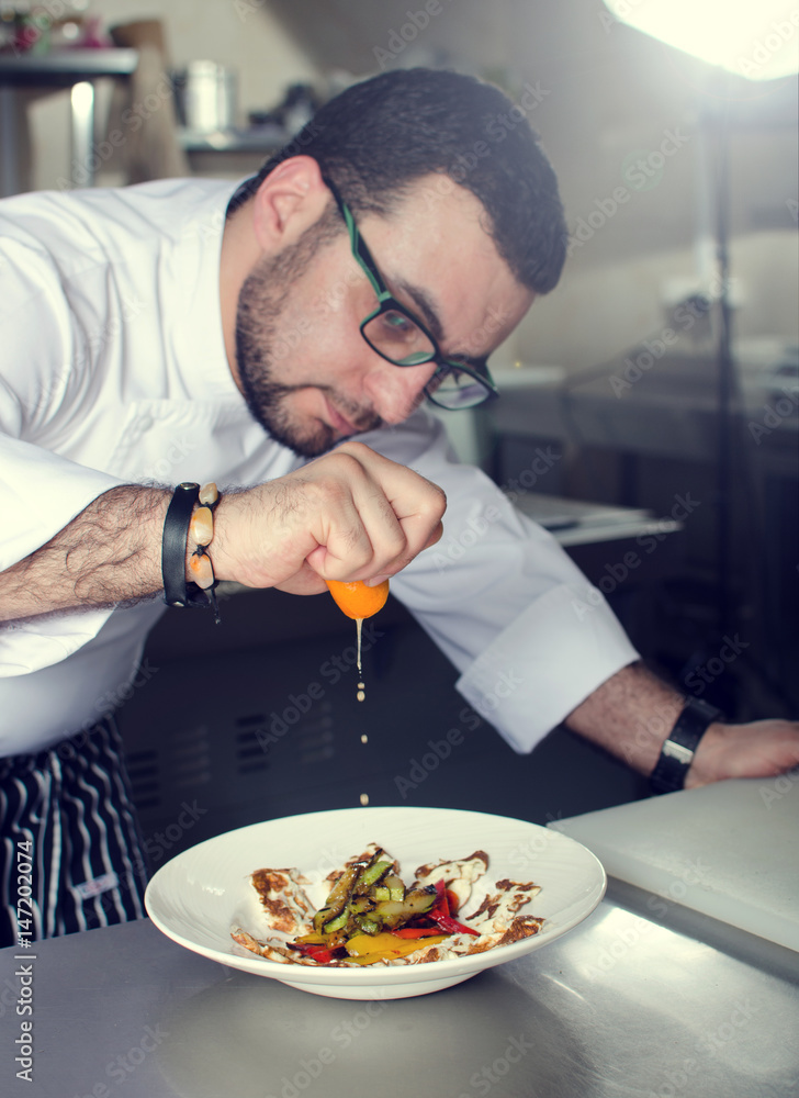 Chef in Restaurant garnishing vegetable dish, crop on hands, filtered image Chef in Restaurant garnishing vegetable dish, crop on hands, filtered image