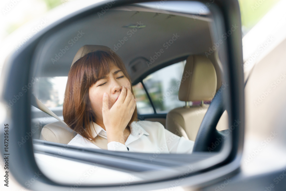 Closeup portrait sleepy, tired young woman driving her car after long hour trip in mirror, Sleep deprivation, accident concept.