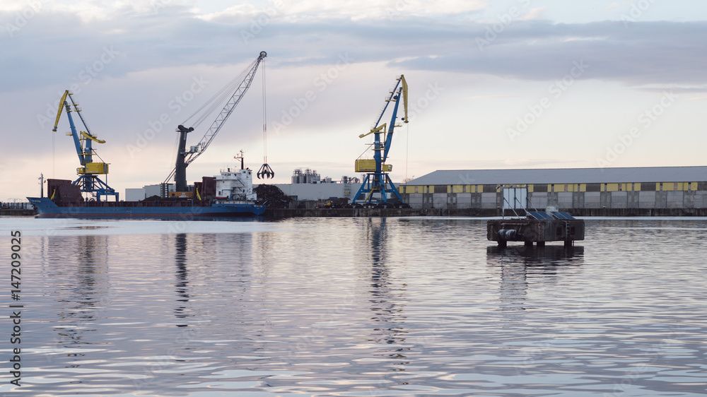 cranes at harbor against sky