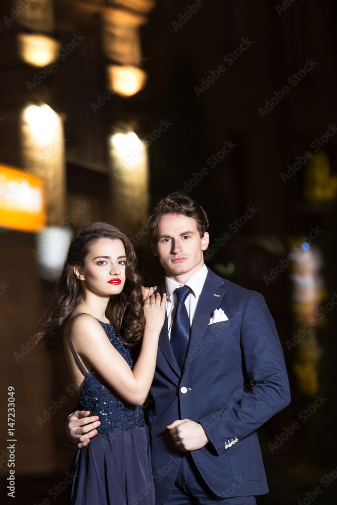 Beautiful young couple walking in the spring in the evening and hugs Beautiful young couple walking in the spring in the evening and hugs
