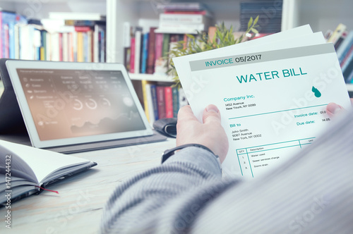 Man holds invoice of water usage