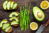 lunch with healthy avocado sandwich on wooden kitchen table background top view
