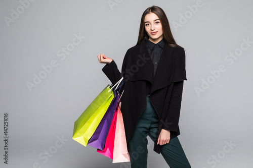 Young beautiful woman with shopping bag on grey