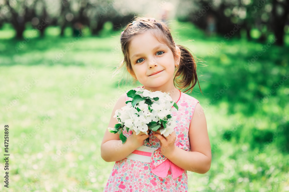 spring closeup outdoor portrait of adorable kid girl. Spending spring holidays in beautiful blooming garden spring closeup outdoor portrait of adorable kid girl. Spending spring holidays in beautiful blooming garden