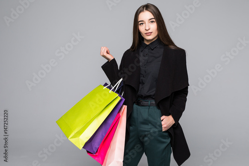 Shopping woman holding bags, isolated on grey studio background