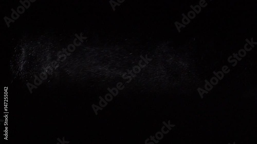 Some dust of liquid particles flowing on dark background photo