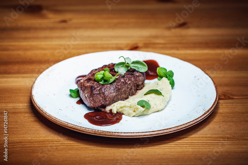 Sliced Gammon Steak with mashed potato on wooden background