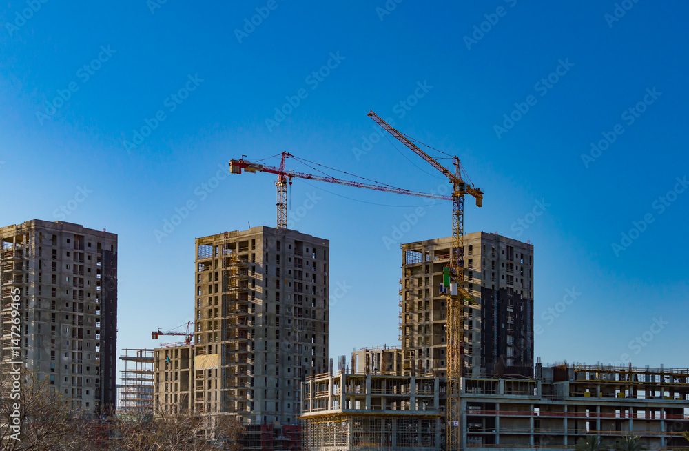 Construction cranes and tall buildings