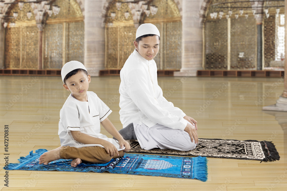 Family praying together in the mosque Family praying together in the mosque