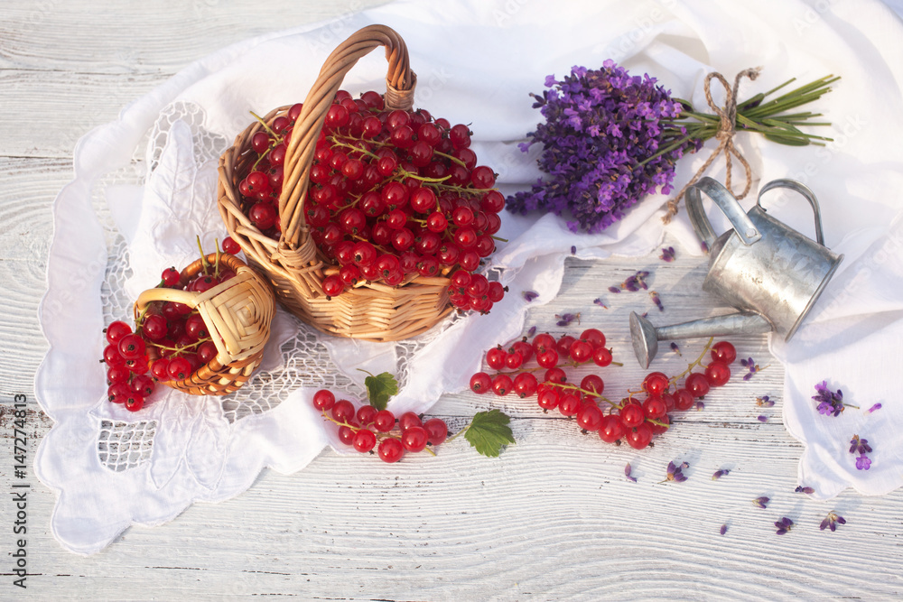 Red currant berries on a table in a basket and lavender flowers