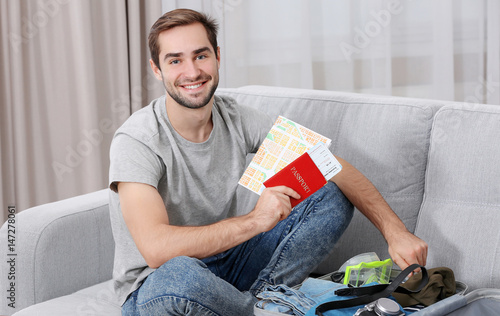 Man packing his grey suitca...