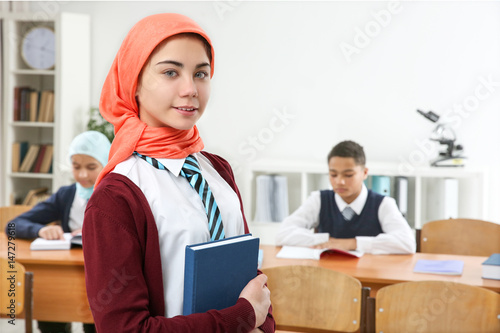 Cute girl with book standin...