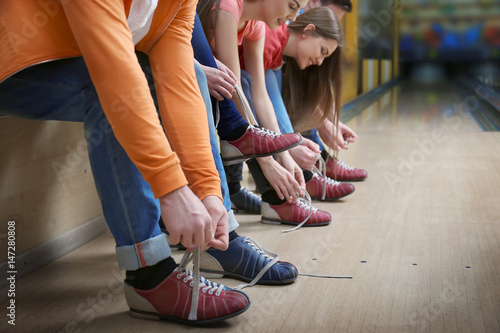 Fotografija Group of young people changing their shoes in bowling club