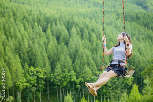 Joyful woman playing on swing