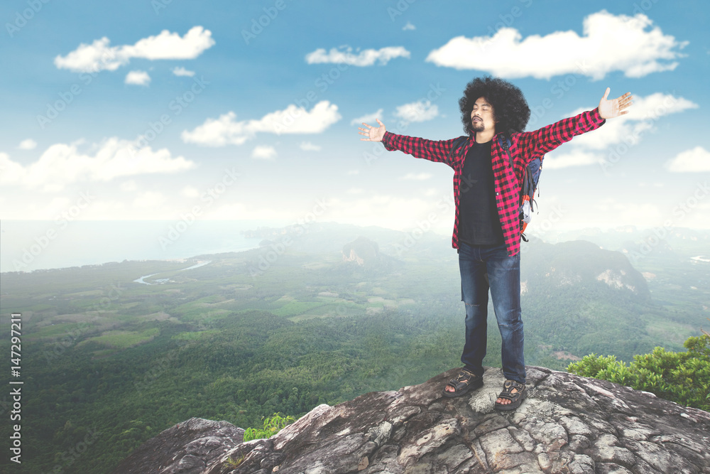 Male hiker open arms at mountain