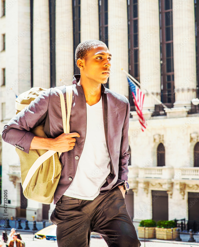 Young African American Man carrying shoulder bag, traveling in New York