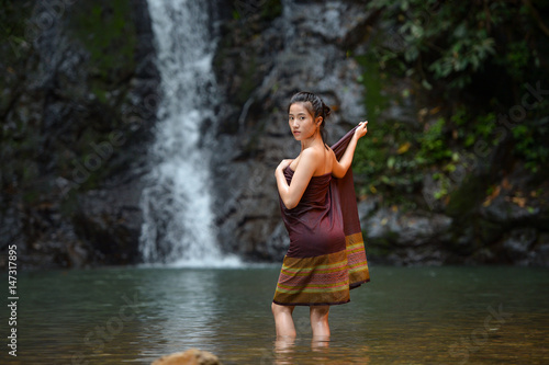 Asian woman wearing traditional thai take a baht on during sunset vintage style Beautiful woman take a baht woman take a baht in river Woman thai culture