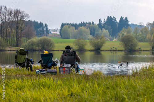 A man relaxing and fishing on the shore of the lake in the spring