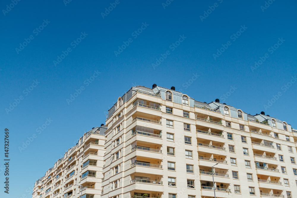 Modern apartment building with balconies and blue sky