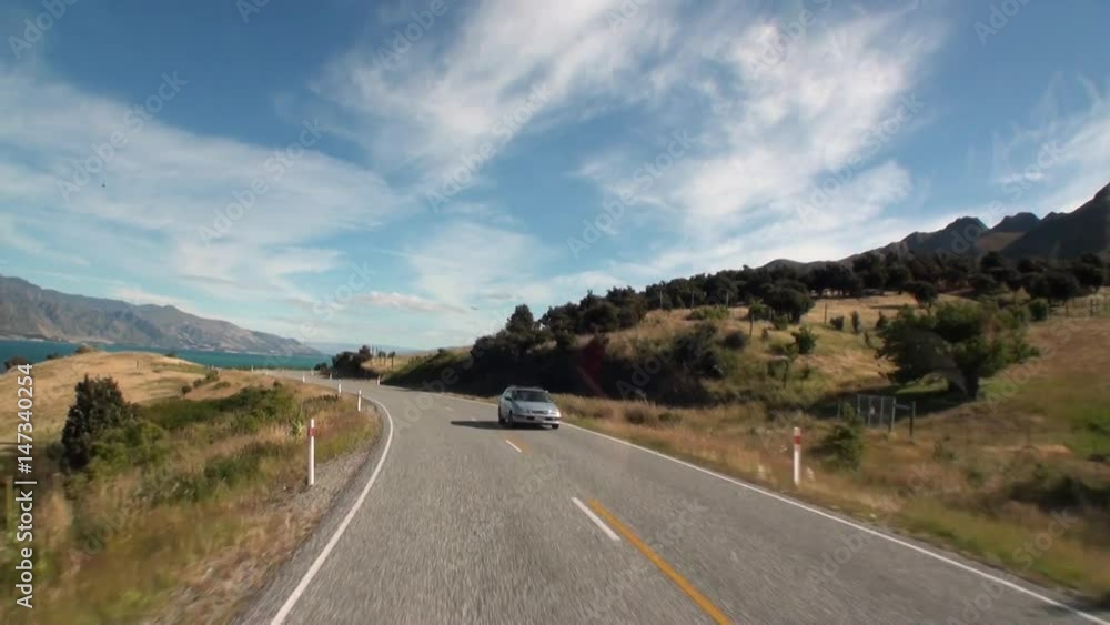 Serpentine road on ocean coast panorama view from car window in New Zealand. Scenic peaks and ridges. Beautiful background of amazing nature. Travel and tourism in the world of wildlife. Serpentine road on ocean coast panorama view from car window in New Zealand. Scenic peaks and ridges. Beautiful background of amazing nature. Travel and tourism in the world of wildlife.