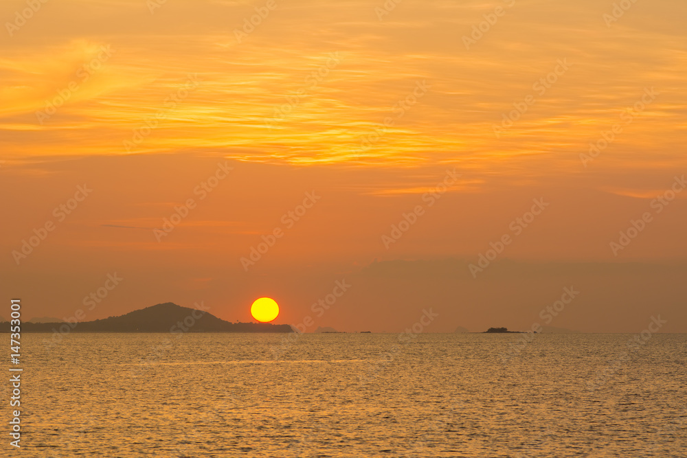 beautiful sky and cloud with orange sunset and silhouette mountain reflecting glows in sea surface