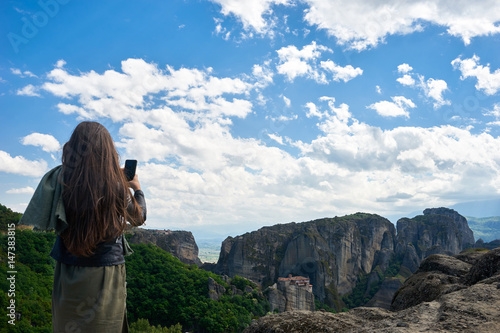 Girl takes a photo with her cell phone the Monastery of Rousanou (St. Barbara), Thessaly, Greece