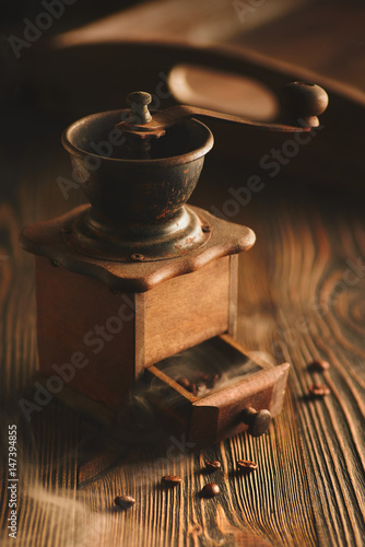 Coffee grinder and bag of roasted coffee on wooden table.