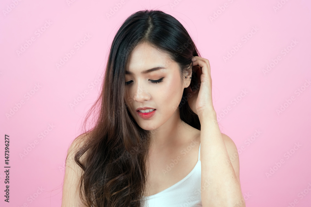 Long hair asian young beautiful woman smile and touch her face, isolated over pink background. natural makeup, SPA therapy, skincare, cosmetology and plastic surgery concept Long hair asian young beautiful woman smile and touch her face, isolated over pink background. natural makeup, SPA therapy, skincare, cosmetology and plastic surgery concept
