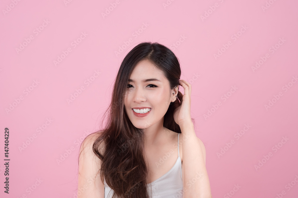 Long hair asian young beautiful woman smile and touch her face, isolated over pink background. natural makeup, SPA therapy, skincare, cosmetology and plastic surgery concept Long hair asian young beautiful woman smile and touch her face, isolated over pink background. natural makeup, SPA therapy, skincare, cosmetology and plastic surgery concept