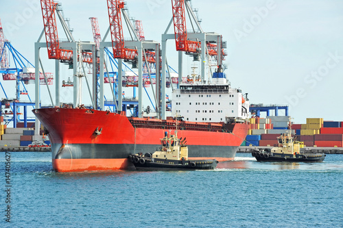 Tugboat assisting bulk cargo ship