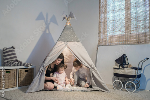 mother reads book in a teepee © familylifestyle
