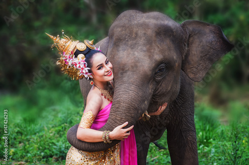 Photography Beautiful Asian Woman wears thai dress with her elephant