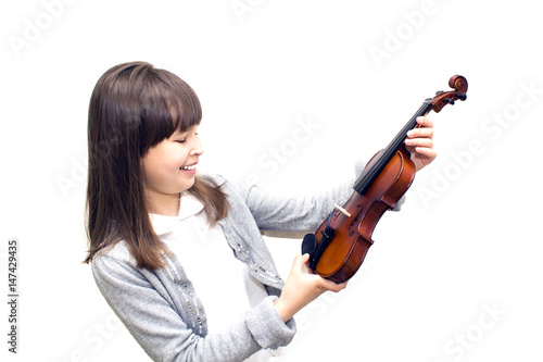 the child holds the violin and smiling.