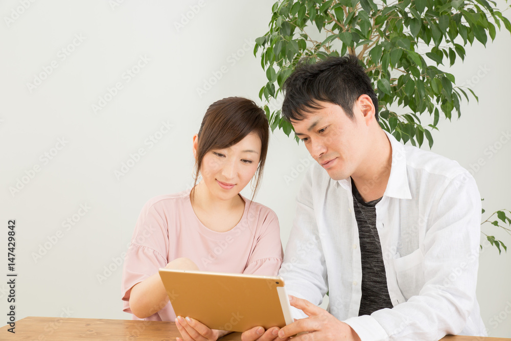 笑顔でタブレットを操作する男女
笑顔でタブレットを操作する男女