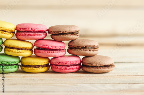 Green  pink  yellow and brown french macarons on the wooden boards