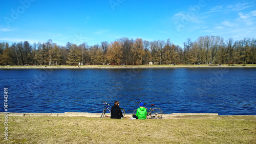 Mother and son are resting on the shore after Cycling. A cool spring day