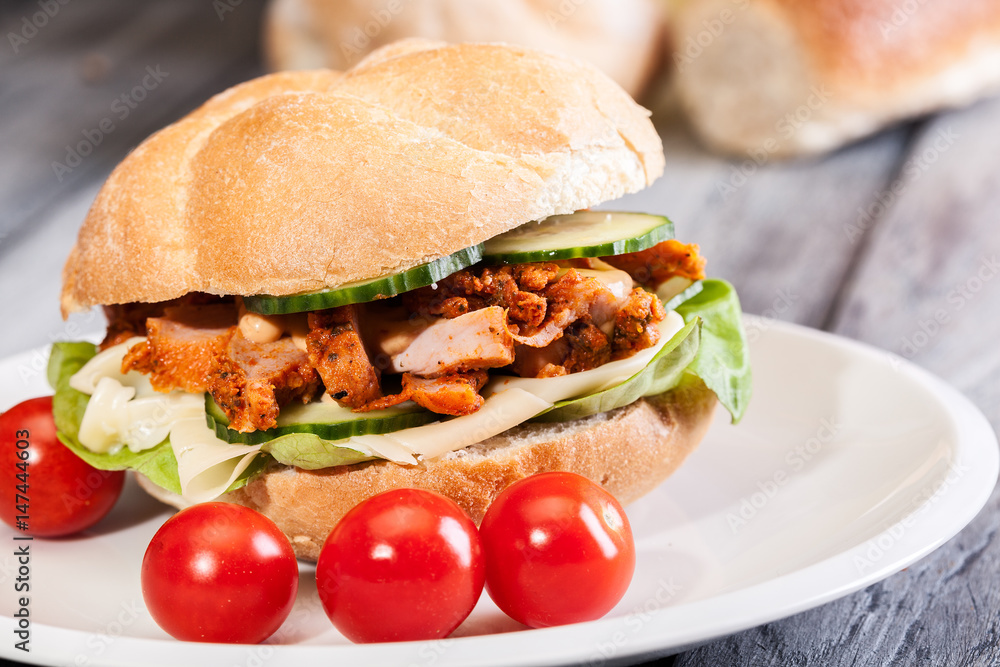 Fried chicken meat with cheese and vegetables in bun Fried chicken meat with cheese and vegetables in bun