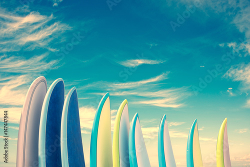Obraz Sterta kolorowi surfboards na niebieskiego nieba tle z kopii przestrzenią, retro rocznika filtr