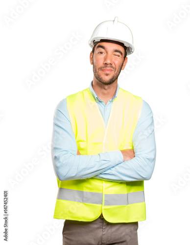 Happy engineer winking an eye against white background