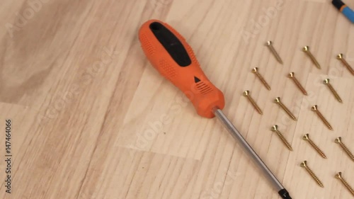 Carpenter screwing the crew with cordless screwdriver into wooden board