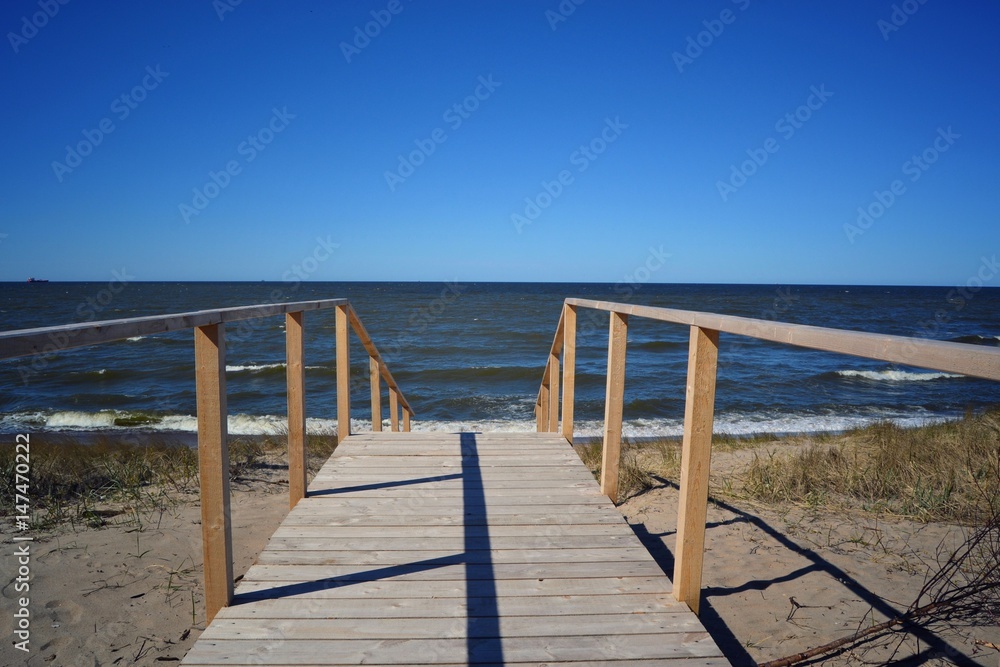 beach sea water pier sky ocean blue sand walkway sun