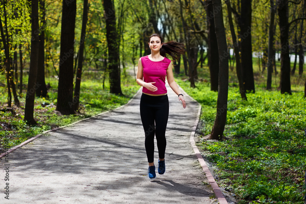 Young pretty fit woman jogging in the park. Young pretty fit woman jogging in the park.