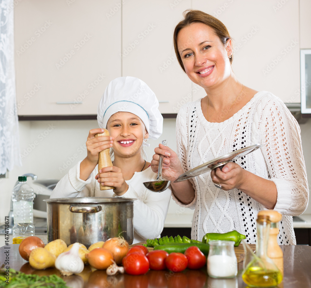 Smiling girl and mom at kitchen