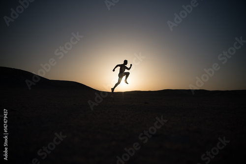 running man silhouette at sunset sky